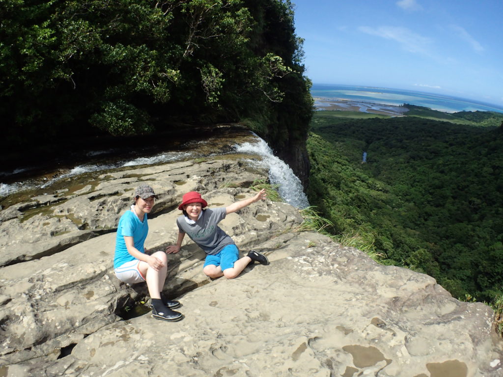 ピナイサーラの滝の落ち口付近で景色を眺めながら休憩するトレッキング参加者