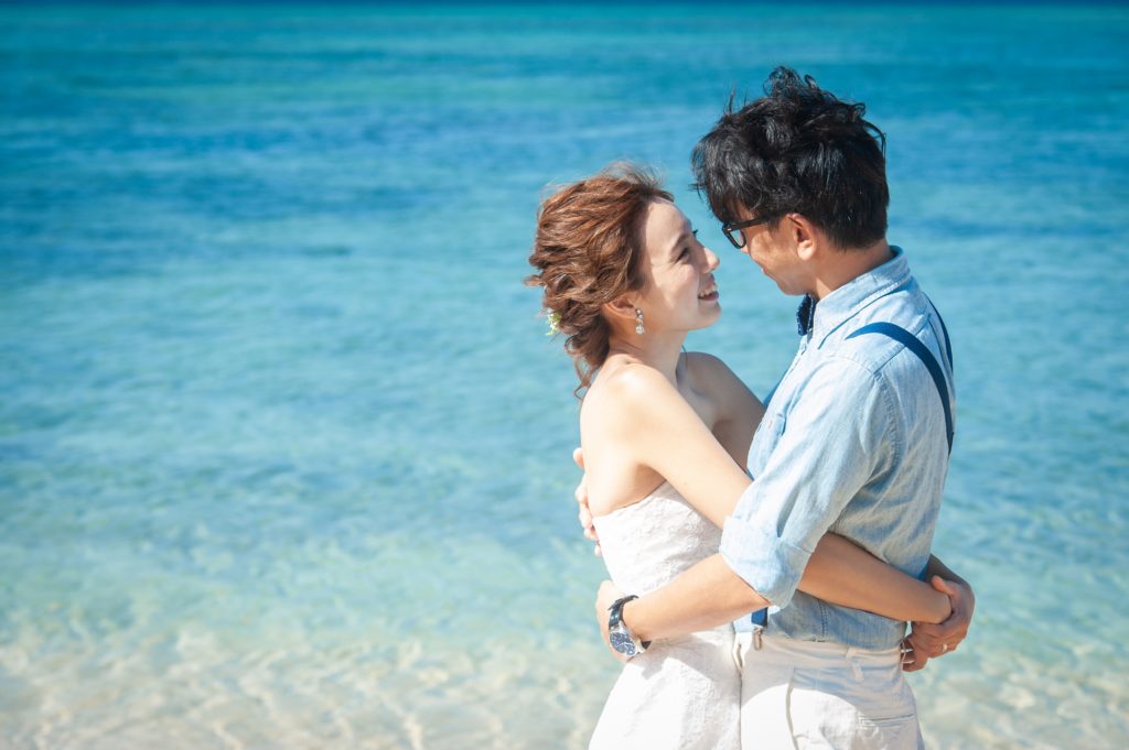 コバルトブルーの海をバックに抱き合うカップル