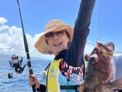 石垣島の海で釣り体験し大きな魚を持つ女性