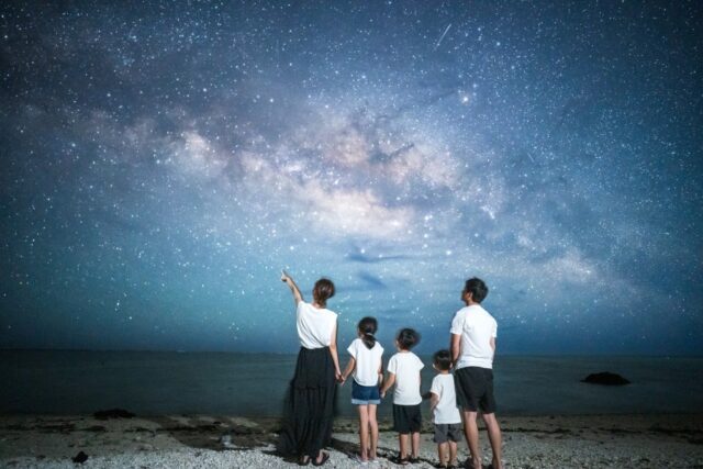 石垣島の星空スポットで家族写真。天の川が輝く夜空と砂浜の絶景。