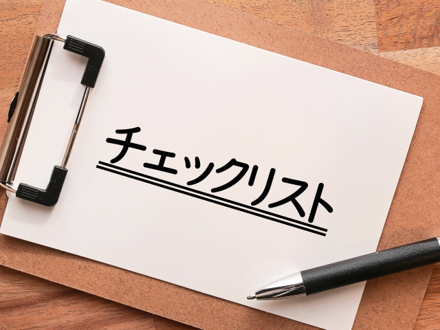 「チェックリスト」と書かれた紙が挟まったバインダーとボールペン。